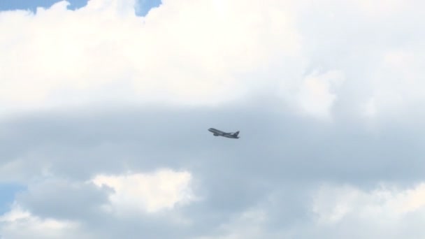 Plane flying across clouds into clear sky — Stock Video