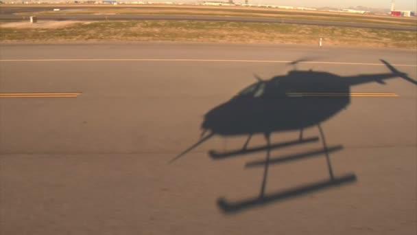 Sombra de helicóptero pairando sobre pista do aeroporto — Vídeo de Stock