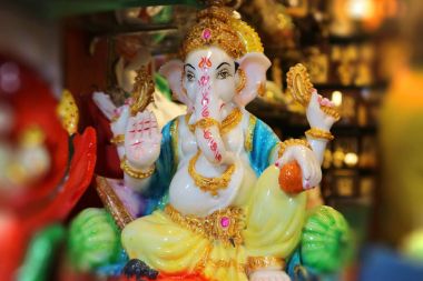 Figurine of God Ganesha. Indian souvenir. Beautiful Ganapati with four arms blesses with a gesture. clipart