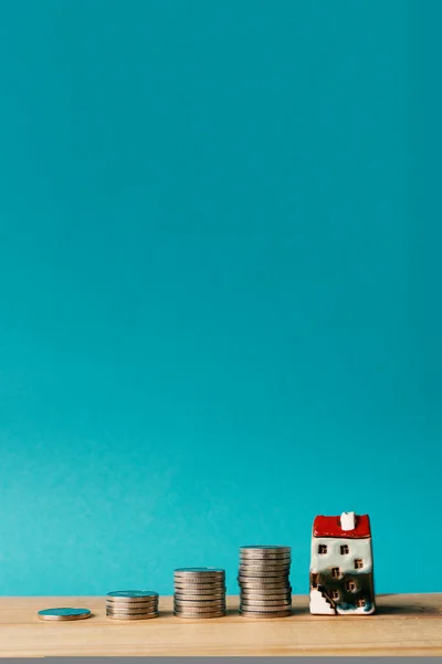 Стоси Монет Рука Тримає Мініатюрний Будинок Синьому Фоні Концепція Накопичення — стокове фото