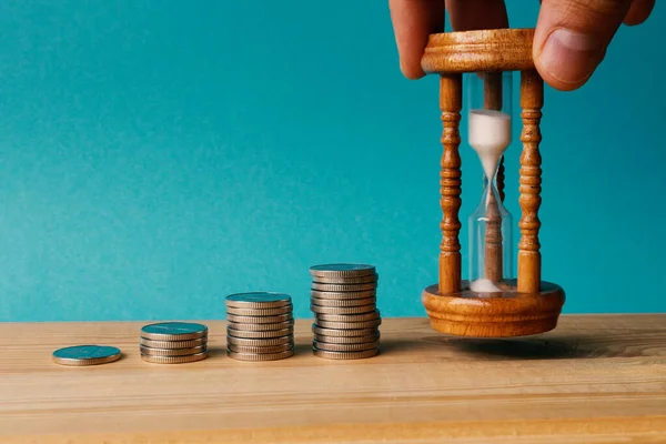 Hand Puts Hourglass Next Coins Stacked Piles Concept Investment Increasing — Stock Photo, Image