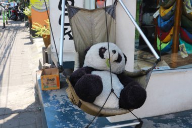 Ubud, Bali, Endonezya - 26 Aralık 2019: Lüks bir panda sallanan bir kamp koltuğunda oturur. 