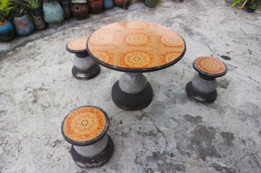 Yuvarlak masa ve üç yuvarlak koltuk..