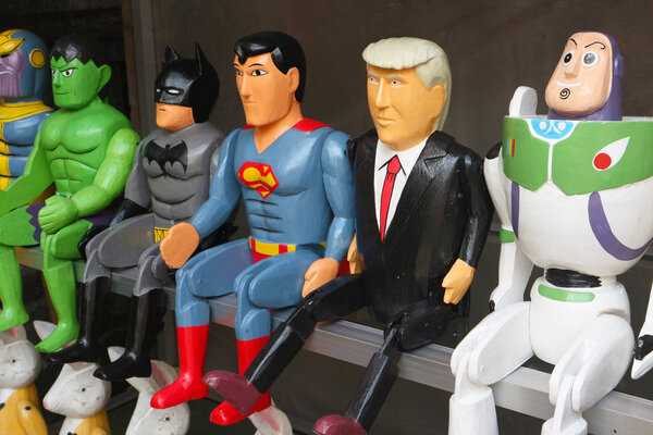 Ubud, Bali, Indonesia - December 26, 2019: US President Donald Trump surrounded by superheroes. Wooden toys on a shelf of a souvenir shop in