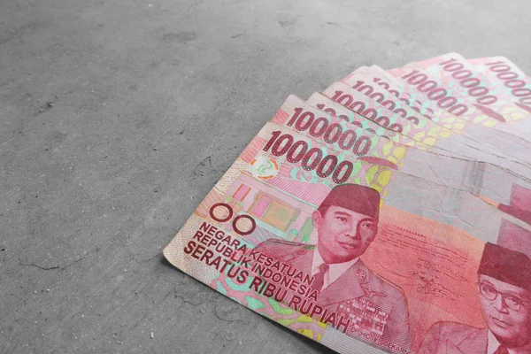 印度尼西亚面额为10万印钞的扇子 背景为灰色 — 图库照片