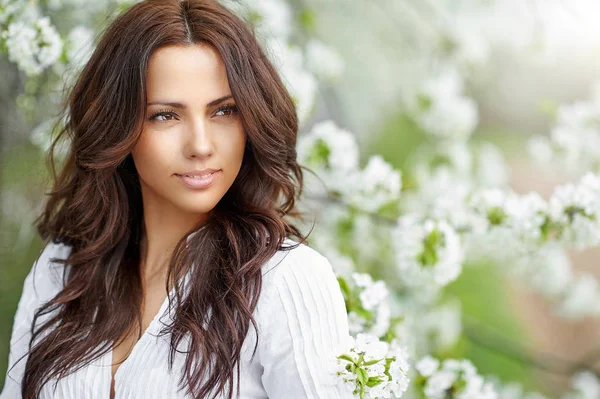 Mooie vrouw in bloeiende tuin in het voorjaar - close-up portret — Stockfoto