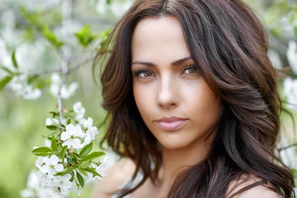 Vacker kvinna i blommande trädgård på våren. Perfekt klart ansikte — Stockfoto