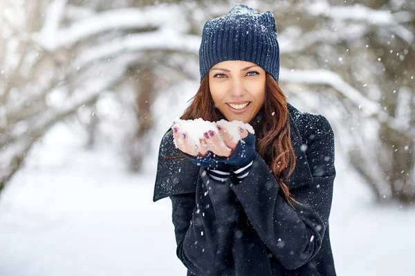 Flicka leker med snö i parken — Stockfoto