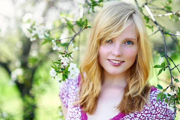 Spring portrait of a beautiful blonde girl in blooming sunny gar — Stok fotoğraf