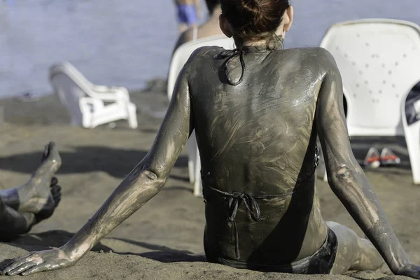 Jovem mulher desfrutando da lama mineral natural proveniente do Mar Morto, Israel. Tratamento de cuidados corporais . — Fotografia de Stock