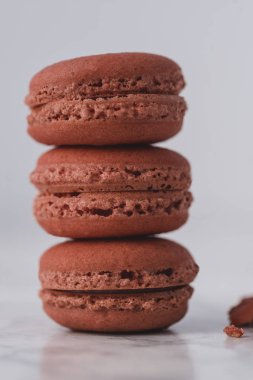 Kırmızı macarons bir beyaz mermer zemin üzerine başka bir yere düzenlenmiştir. Yakın çekim.