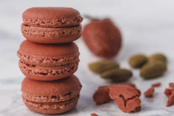 Rote Macarons übereinander auf weißem Marmorgrund angeordnet. Nahaufnahme. — Stockfoto