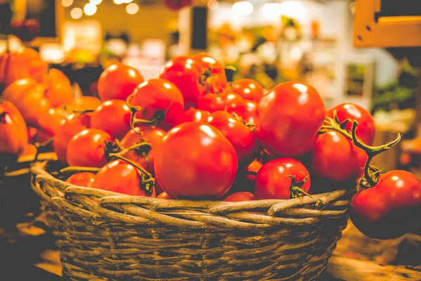 Cesta rústica de tomates orgânicos frescos em fundo escuro no mercado de agricultores . — Fotografia de Stock