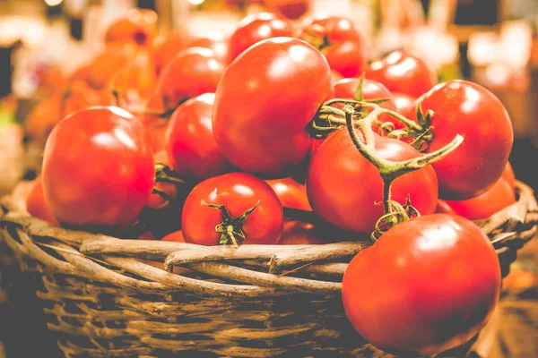 Cesta rústica de tomates orgânicos frescos em fundo escuro no mercado de agricultores . — Fotografia de Stock