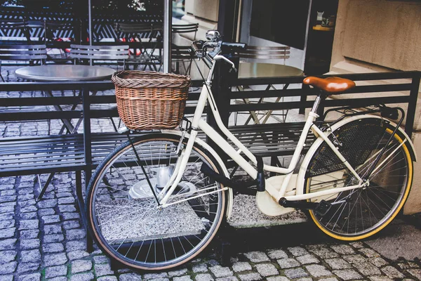 Healthy transport concept. Vintage bicycle left near cafe with old wooden basket in Italy, Milan. Outdoor shot.