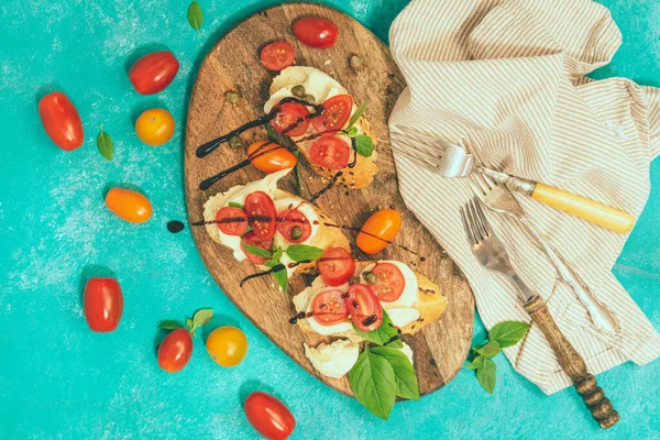 Bruschetta caprese casera con sabrosos tomates cherry, albahaca fresca, mozzarella y pan crujiente —  Fotos de Stock