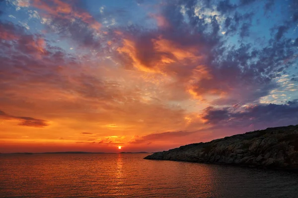Schöner farbenfroher Sonnenuntergang am Meer mit dramatischen Wolken und lizenzfreie Stockbilder