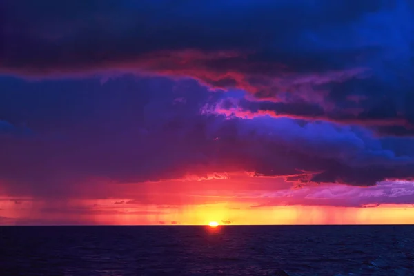 Natürliche violette Farbe Sonnenuntergang oder Sonnenaufgang Himmel über stürmischem regnerischem Meer Stockfoto