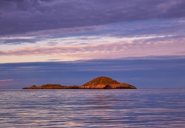 Güzel günbatımı gökyüzü ve yansıma ile adanın sakin denizde