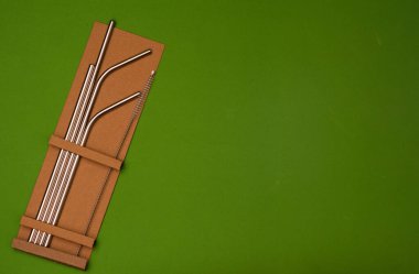 Yeşil arka plandaki karton kutuda yeniden kullanılabilir pipetler