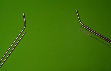 Yeşil arka planda yeniden kullanılabilir pipet ve temizlik fırçası