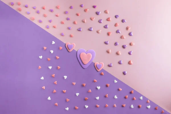 Belo plano leigos padrão de corações com três corações multicoloridos no meio — Fotografia de Stock