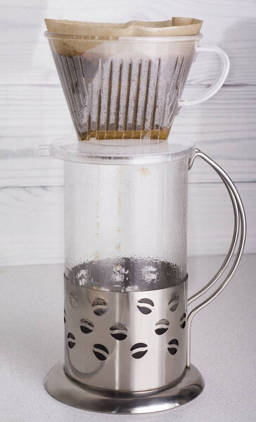 верхний вид процесса пивоварения молотого кофе в воронке v60 и слива его в сосуд
