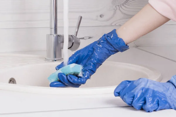 Τα χέρια σε μπλε γάντια πλένουν το νεροχύτη με σφουγγάρι — Φωτογραφία Αρχείου