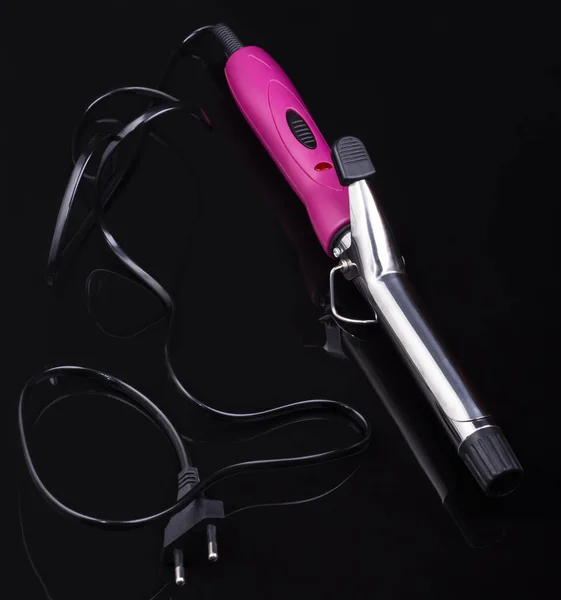 Electric hair curler on black mirror background with copy space — Stockfoto