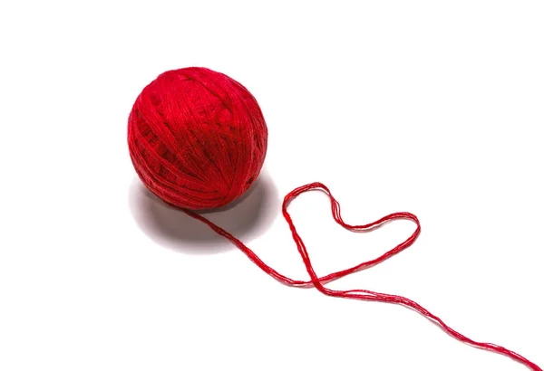 Шерсть Skein красная нить в форме сердца на белом фоне — стоковое фото