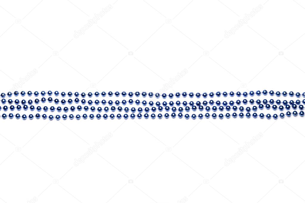 beads laid out in straight rows on Mardi Gras blue on white background