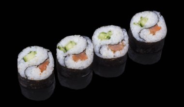 Dört lezzetli Yin-Yang suşisi siyah bir arkaplanda yansımalı.
