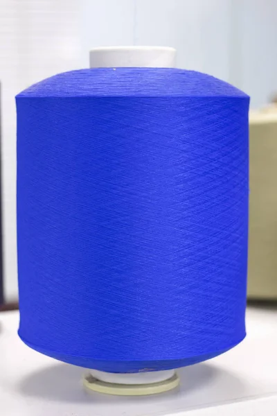 Bobina con hilo elástico azul en la máquina de tejer — Foto de Stock