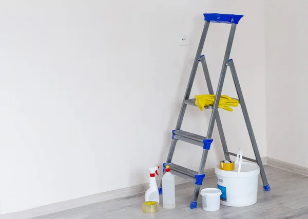 Boya kutuları ve aletlerle dolu bir merdiven. Parlak yenilenmiş bir odada, boşluğun bir kopyasıyla.