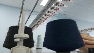 İşlem sırasında örgü makinesinin üzerindeki renkli iplik bobinleri.