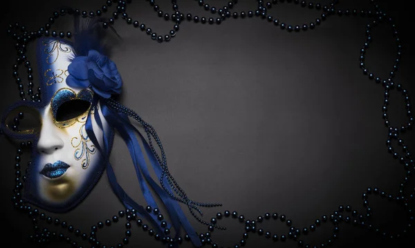 Blue mask for Mardi Gras on a black background with beads — Stock Photo, Image
