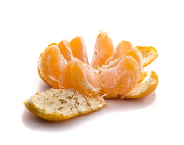 Один очищенный апельсиновый мандарин на белом фоне, на кожуре с разделенными ломтиками — стоковое фото