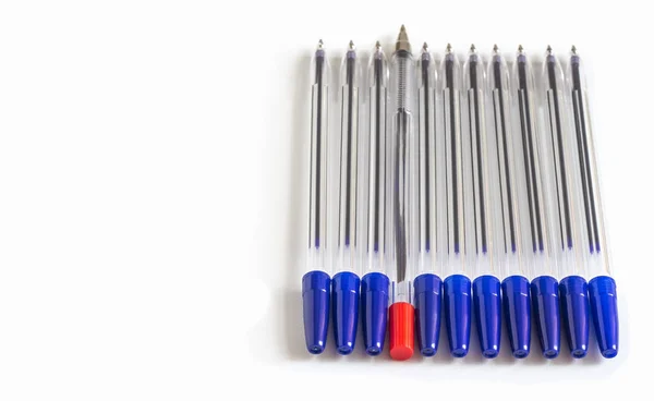 Un stylo à bille rouge parmi de nombreux stylos à bille bleu — Photo