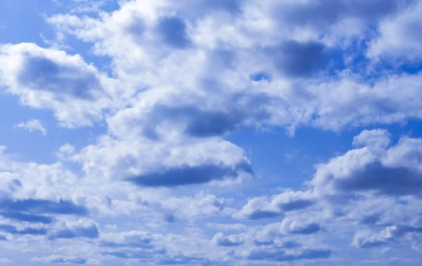 Cielo azul con muchas nubes iluminadas por el sol — Foto de Stock