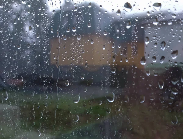 Fuori dalla finestra piove forte, gocce di pioggia sulla finestra, tempo piovoso — Foto Stock