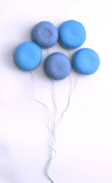 Macarrones franceses azul plano yacía en forma de globos en las cuerdas —  Fotos de Stock