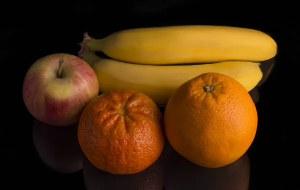 Свежие фруктовые бананы с апельсином с яблоком и мандарином на черном фоне — стоковое фото