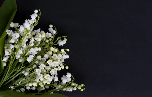 Witte delicate lelies van de vallei op een zwarte textuur achtergrond — Stockfoto