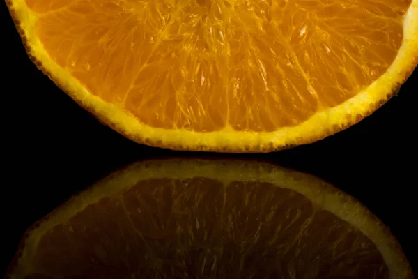 Slice of fresh orange on a black background with reflection — Stock Photo, Image