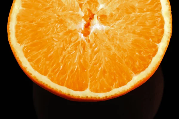 Кусок свежего апельсина на черном фоне — стоковое фото