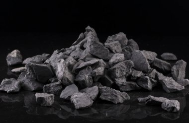 Bir karbon minerali olan mineral shungite, siyah arka planda olağanüstü su arıtma kalitesi sağlar..