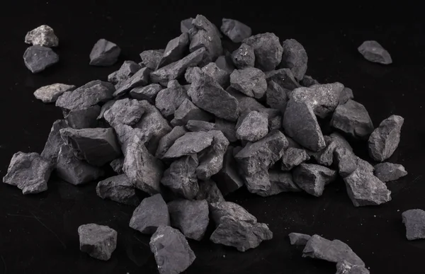 Bir karbon minerali olan Shungite taşı, siyah arkaplanda olağanüstü su arıtma kalitesi sağlar..