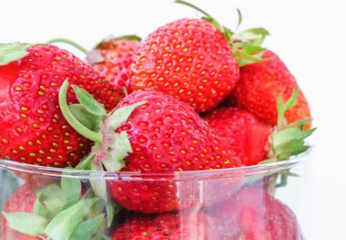 Olgun taze çilekleri cam bir vazoda yakın plan çek..