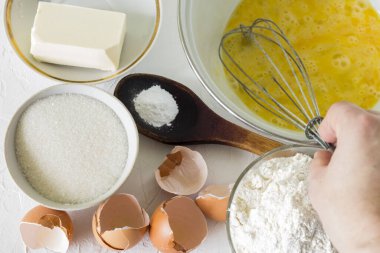 Bir pasta için kısa hamur işi yapmak için malzemelerin üzerinde çırpılmış bir el..