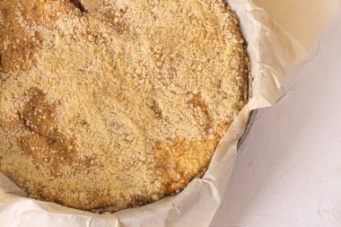 Beyaz desenli arka planda taze pişmiş, kaymaklı turta, yakın plan..